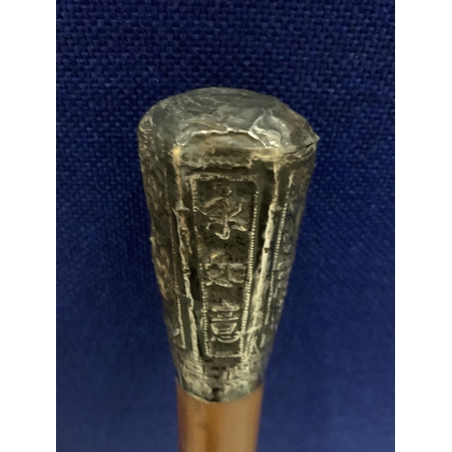 71 - A WALKING STICK WITH A POSSIBLY CONTINENTAL SILVER ORNATE TOP