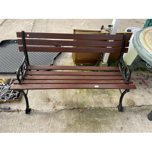 1853 - A WOODEN SLATTED GARDEN BENCH WITH CAST ENDS