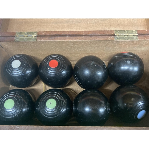 1083 - EIGHT CARPET BOWLS IN A WOODEN BOX