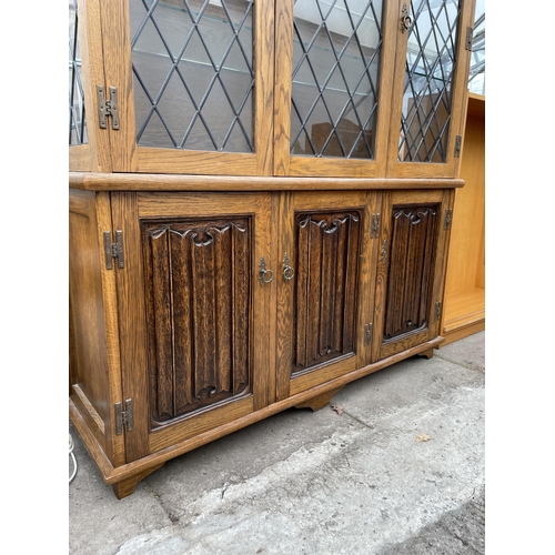 3142 - AN OAK OLD CHARM STYLE BOOKCASE WITH GLAZED AND LOADED UPPER PORTION AND LINEN-FOLD DOORS TO BASE - ... 