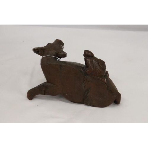 202 - AN ORIENTAL WOODEN CARVED WATER BUFFALO WITH CHILD RIDER, A/F TO LEG, HEIGHT 12CM, LENGTH 22CM