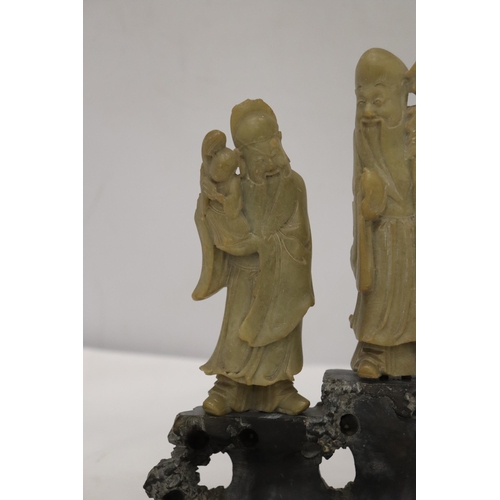 109 - AN ORIENTAL CARVING OF THREE ELDERS ON A PLINTH, HEIGHT 21CM, WIDTH 22CM