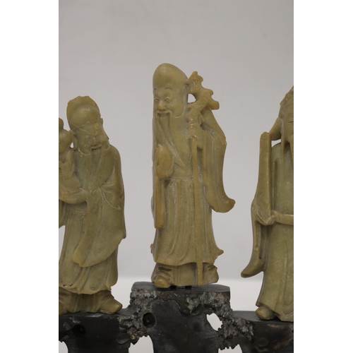 109 - AN ORIENTAL CARVING OF THREE ELDERS ON A PLINTH, HEIGHT 21CM, WIDTH 22CM