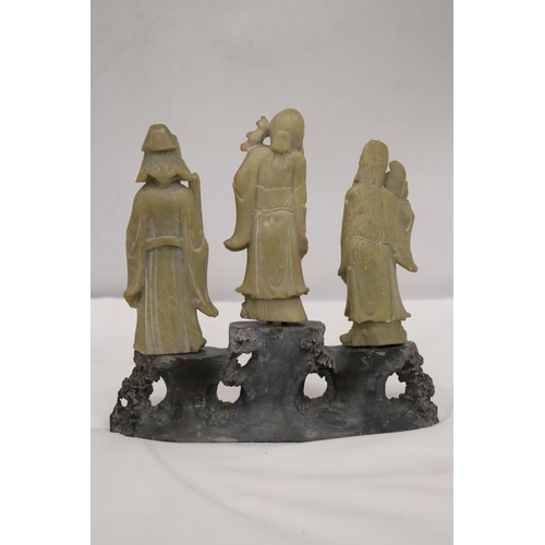 109 - AN ORIENTAL CARVING OF THREE ELDERS ON A PLINTH, HEIGHT 21CM, WIDTH 22CM