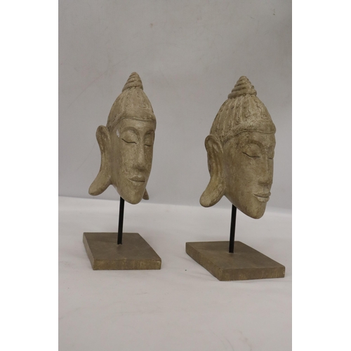 135 - TWO BUDDAH HEADS ON STANDS, HEIGHT 27CM