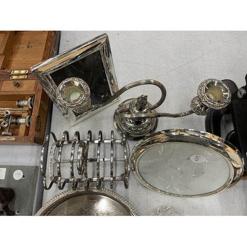 176 - A QUANTITY OF SILVER PLATED ITEMS TO INCLUDE TRAYS, A CANDLEABRA, TOAST RACK, BUD VASES, SUGAR SIFTE... 