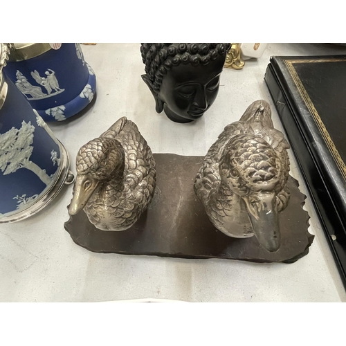 231 - A VINTAGE PAIR OF WHITE METAL DUCKS ON A WOODEN PLINTH