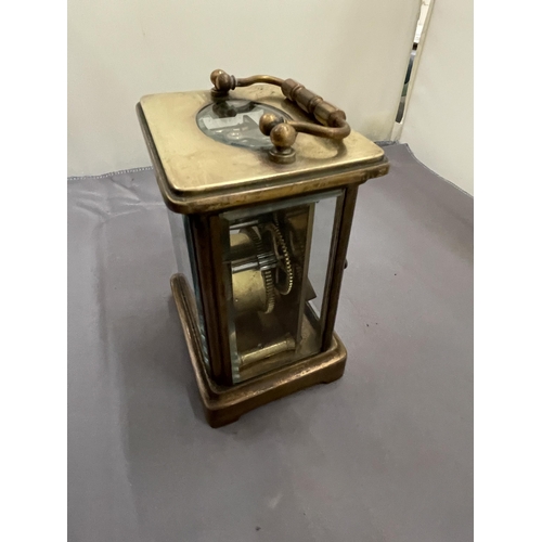 251 - A VINTAGE BRASS CARRIAGE CLOCK WITH BEVELLED GLASS REVEALING THE INNER WORKINGS