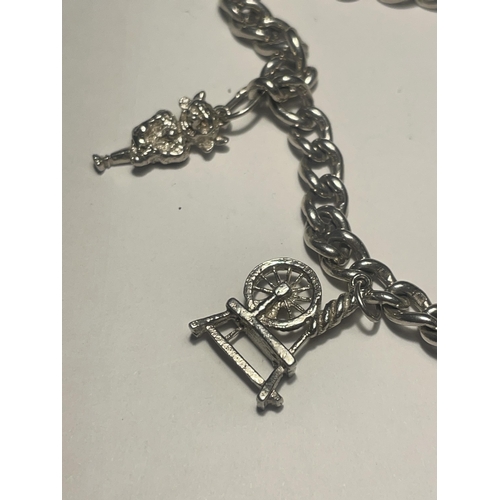 620 - A SILVER CHARM BRACELET WITH FIVE CHARMS AND A HALLMARKED BIRMINGHAM SILVER SAFETY PADLOCK