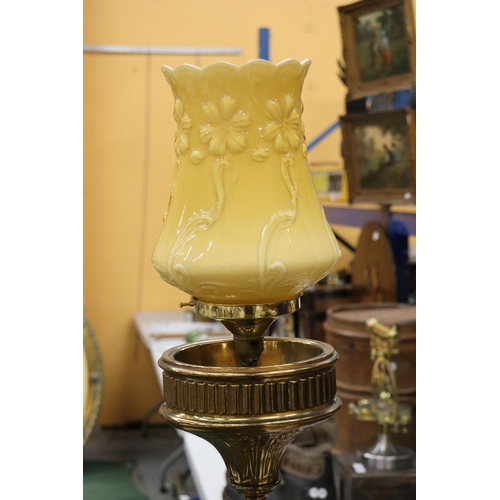 13 - A FLOOR STANDING BRASS PUGIN STYLE CONVERTED CANDLESTICK WITH ORNAGE GLASS SHADE