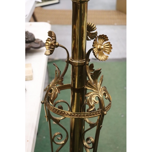 13 - A FLOOR STANDING BRASS PUGIN STYLE CONVERTED CANDLESTICK WITH ORNAGE GLASS SHADE