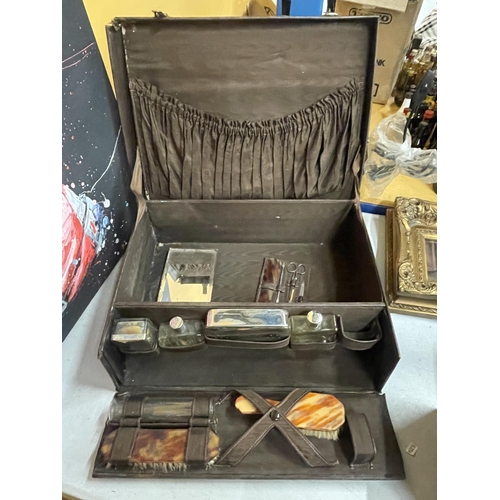 67 - A GENTLEMAN'S TRAVEL CASE WITH CONTENTS TO INCLUDE BOTTLES AND BRUSHES WITH INDISTINCT LABEL TO LID
