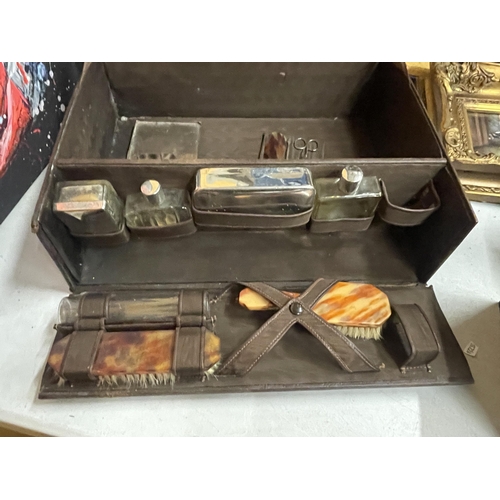 67 - A GENTLEMAN'S TRAVEL CASE WITH CONTENTS TO INCLUDE BOTTLES AND BRUSHES WITH INDISTINCT LABEL TO LID