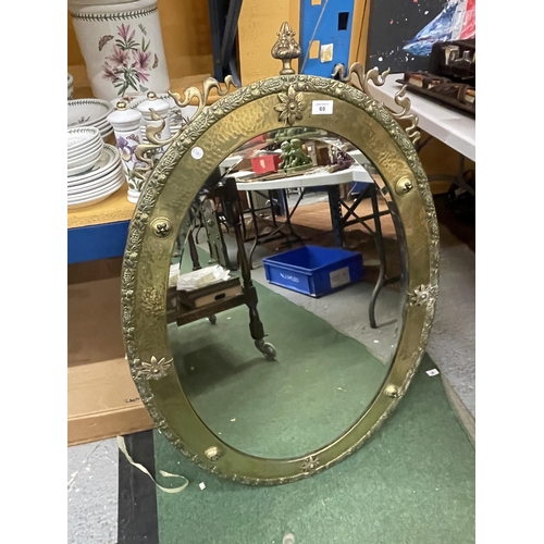 69 - A LARGE BRASS FRAMED ARTS AND CRAFTS OVAL MIRROR