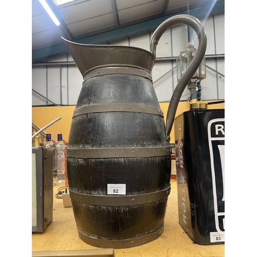 82 - A LARGE OAK AND BRASS BANDED JUG WITH BRASS HANDLE AND TOP HEIGHT 57CM