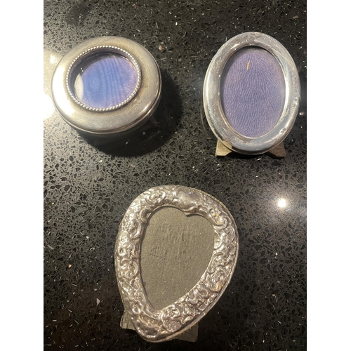 93 - THREE MINIATURE HALLMARKED SILVER PHOTOGRAPH FRAMES TO INCLUDE A DECORATIVE HEART SHAPED EXAMPLE