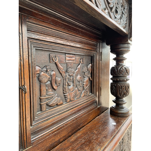 2655 - AN OAK GEORGE III STYLE COURT CUPBOARD WITH CARVED PANELS, THREE DEPICTING THE BIRTH AND CRUCIFIXION... 