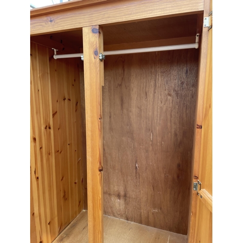 2675 - A PINE TWO DOOR WARDROBE WITH TWO DRAWERS TO BASE