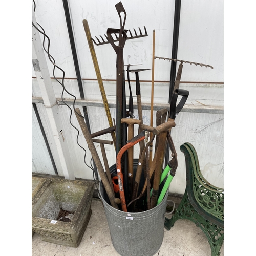 1661 - A GALVANISED DUST BIN WITH AN ASSORTMENT OF GARDEN TOOLS TO INCLUDE RAKES AND HOES ETC