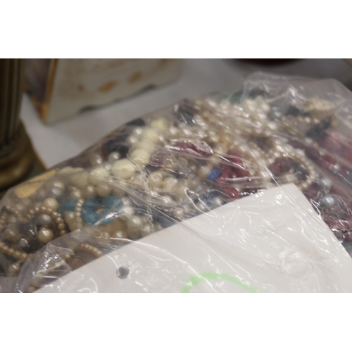 827 - A 10KG BAG OF COSTUME JEWELLERY CONTAINING CHAINS, BRACELETS AND BEADS