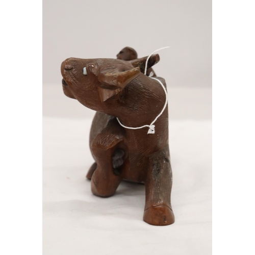 873 - AN ORIENTAL WOODEN CARVED WATER BUFFALO WITH CHILD RIDER, A/F TO LEG, HEIGHT 12CM, LENGTH 22CM