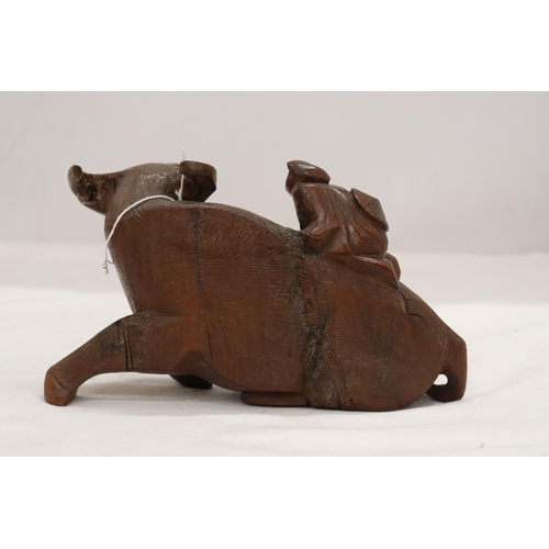 873 - AN ORIENTAL WOODEN CARVED WATER BUFFALO WITH CHILD RIDER, A/F TO LEG, HEIGHT 12CM, LENGTH 22CM