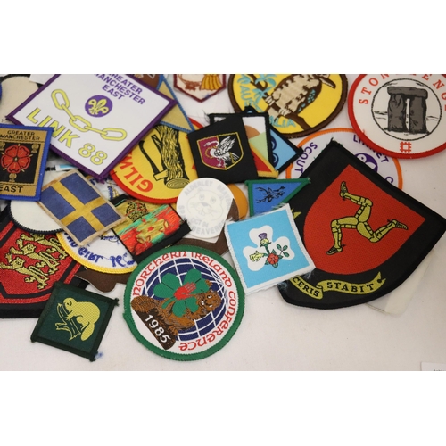 900 - A LARGE COLLECTION OF CLOTH AND PIN BADGES TO INCLUDE GIRL GUIDES, BEAVERS, HOLIDAY DESTINATIONS, ET... 