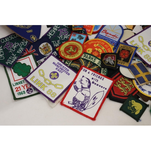 900 - A LARGE COLLECTION OF CLOTH AND PIN BADGES TO INCLUDE GIRL GUIDES, BEAVERS, HOLIDAY DESTINATIONS, ET... 