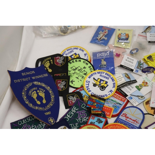 900 - A LARGE COLLECTION OF CLOTH AND PIN BADGES TO INCLUDE GIRL GUIDES, BEAVERS, HOLIDAY DESTINATIONS, ET... 