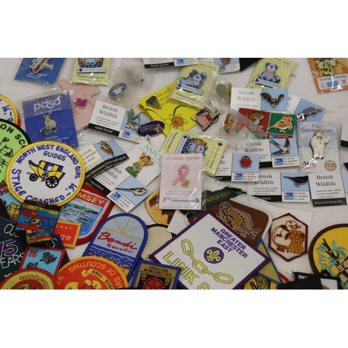 900 - A LARGE COLLECTION OF CLOTH AND PIN BADGES TO INCLUDE GIRL GUIDES, BEAVERS, HOLIDAY DESTINATIONS, ET... 