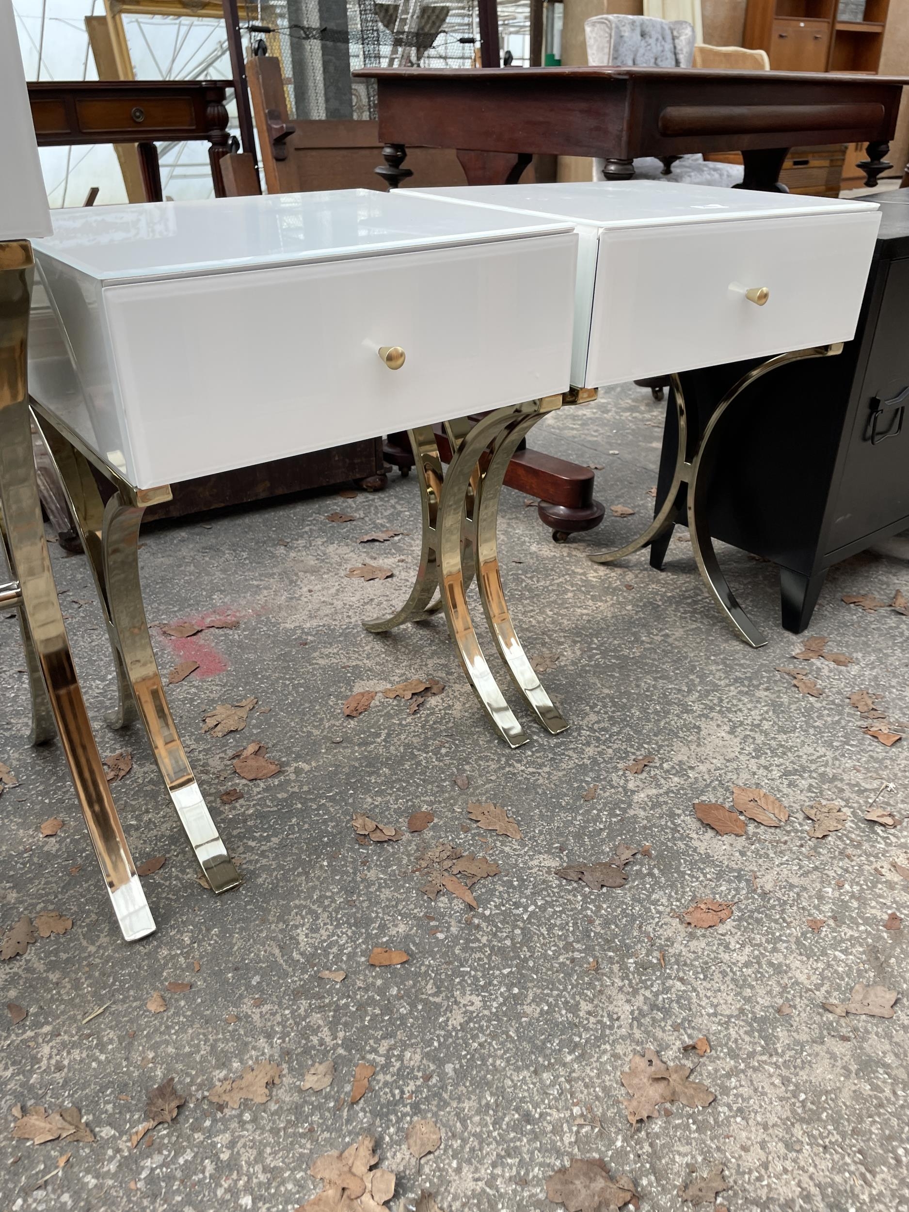 A WHITE DRESSING TABLE ON X FRAME LEGS AND A PAIR OF MATCHING BEDSIDE ...