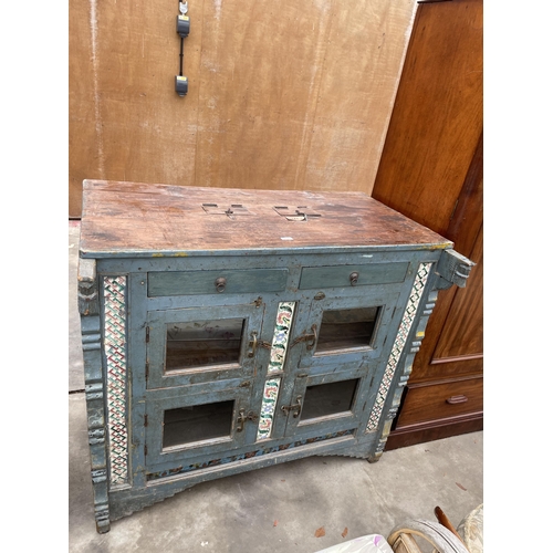 2936 - A VINTAGE INDIAN HARDWOOD CABINET ENCLOSING FOUR GLAZED CUPBOARDS AND TWO DRAWERS WITH INSET COLOURE... 