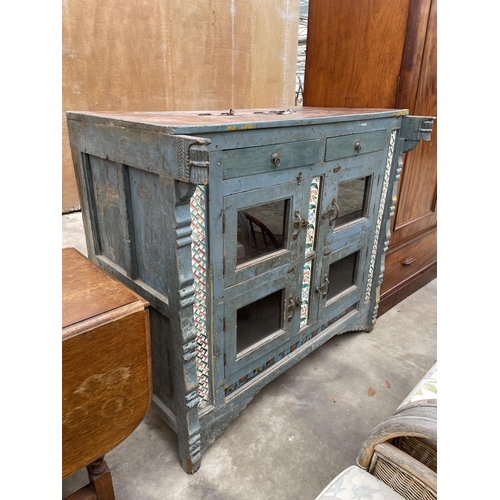 2936 - A VINTAGE INDIAN HARDWOOD CABINET ENCLOSING FOUR GLAZED CUPBOARDS AND TWO DRAWERS WITH INSET COLOURE... 