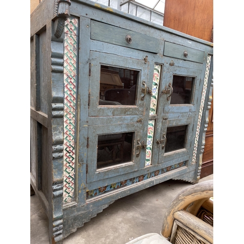 2936 - A VINTAGE INDIAN HARDWOOD CABINET ENCLOSING FOUR GLAZED CUPBOARDS AND TWO DRAWERS WITH INSET COLOURE... 