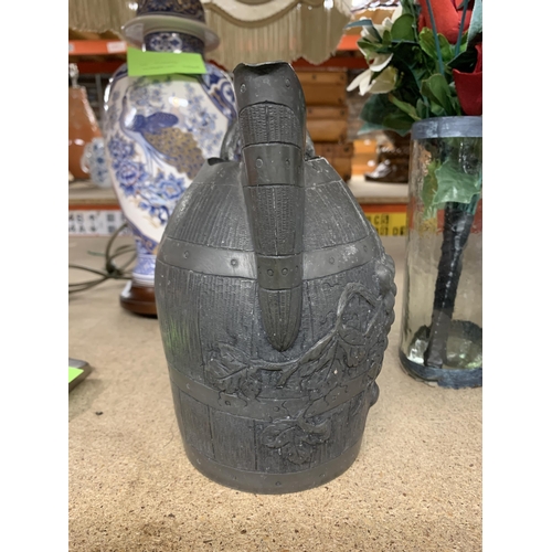 1179 - A VINTAGE PEWTER WINE JUG IN THE FORM OF A BARREL WITH GRAPE AND VINE DECORATION, HEIGHT 19CM