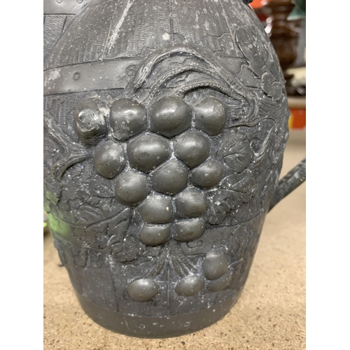 1179 - A VINTAGE PEWTER WINE JUG IN THE FORM OF A BARREL WITH GRAPE AND VINE DECORATION, HEIGHT 19CM