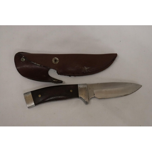 948 - A HUNTING KNIFE IN A LEATHER SHEATH