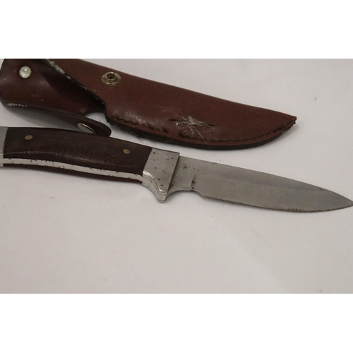 948 - A HUNTING KNIFE IN A LEATHER SHEATH