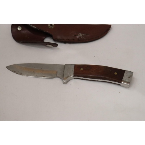 948 - A HUNTING KNIFE IN A LEATHER SHEATH