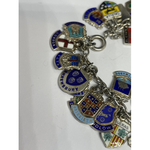 630 - A SILVER CHARM BRACELET WITH FORTY ENAMEL PLACE NAME CHARMS