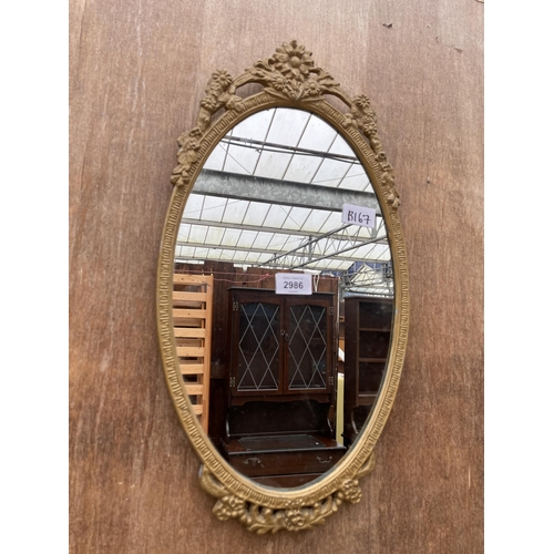 2986 - AN OVAL GILT METAL WALL MIRROR, 19