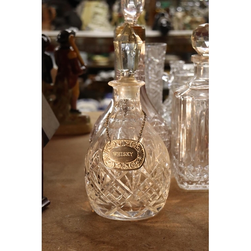 1036 - FOUR CUT GLASS DECANTERS ONE WITH A WHISKEY DECANTER LABEL