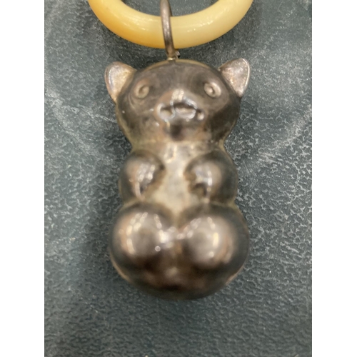 120A - AN EARLY 20TH CENTURY TEETHING RING WITH TEDDY BEAR CHARM