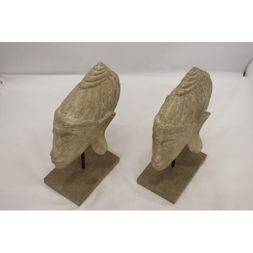 135 - TWO BUDDAH HEADS ON STANDS, HEIGHT 27CM