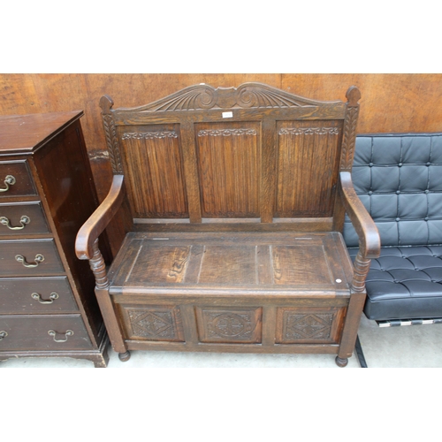 2519 - AN OAK JACOBEAN STYLE SETTLE WITH LINENFOLD BACK, CARVED PANEL FRONT AND LIFT-UP SEAT, 42