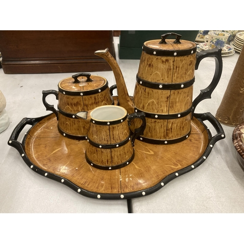 119 - A CERAMIC TEASET ON A TRAY TO INCLUDE A COFFEE POT, SUGAR BOWL AND CREAM JUG, IN A BARREL STYLE DESI... 