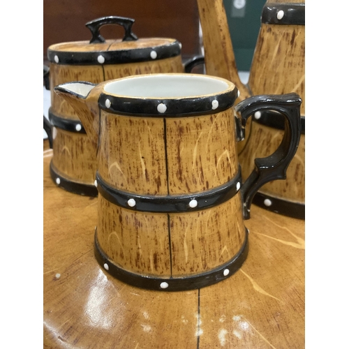 119 - A CERAMIC TEASET ON A TRAY TO INCLUDE A COFFEE POT, SUGAR BOWL AND CREAM JUG, IN A BARREL STYLE DESI... 