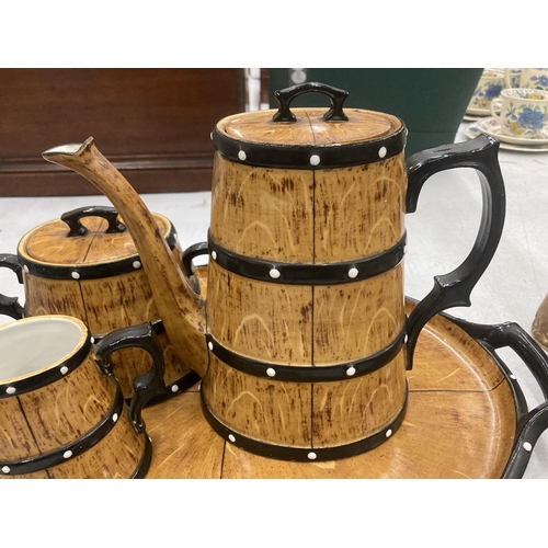 119 - A CERAMIC TEASET ON A TRAY TO INCLUDE A COFFEE POT, SUGAR BOWL AND CREAM JUG, IN A BARREL STYLE DESI... 