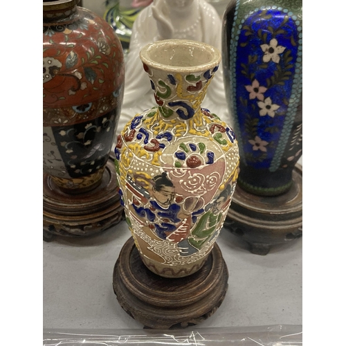 236 - THREE ORIENTAL VASES ON WOODEN STANDS TO INCLUDE CLOISONNE, A SEATED FIGURE, ETC