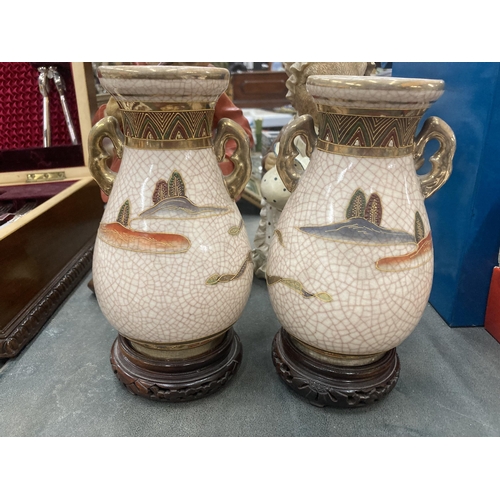 248 - A PAIR OF TWIN HANDLED SATSUMA VASES ON WOODEN STANDS